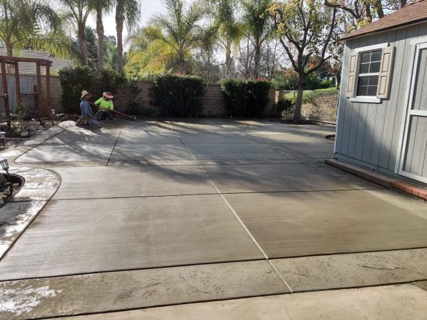 Concrete patio installation, featuring a modern design with sleek lines and a spacious layout.