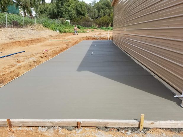Building a concrete driveway on a bright day.