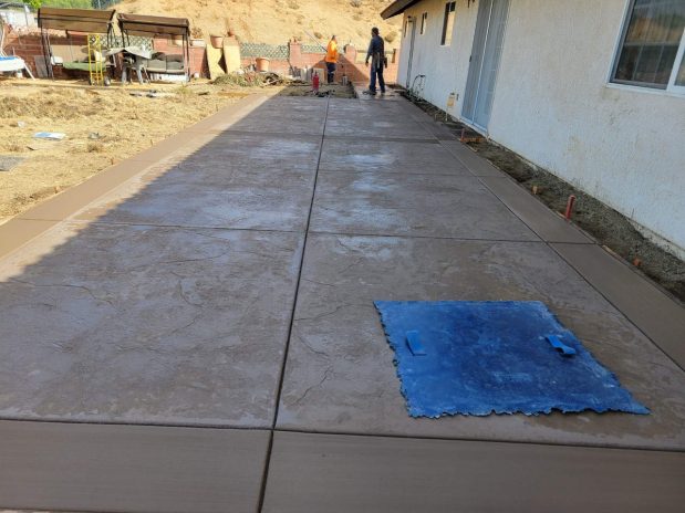 Freshly laid concrete patio in front of a residential home.