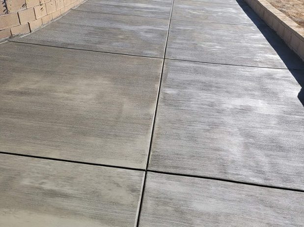 A concrete driveway and walkway leading up to a house.