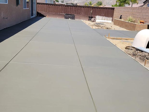 A spacious concrete patio with a large slab, perfect for outdoor gatherings and relaxation.