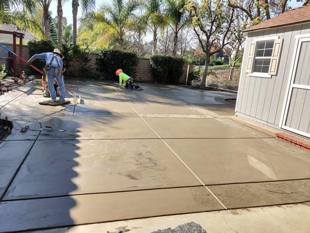 A newly installed concrete patio showcasing a sleek and contemporary outdoor space.