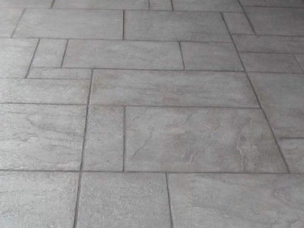 A stone wall and concrete patio in an outdoor living space.