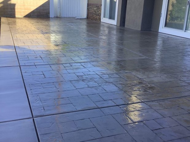 Concrete patio with stone wall, perfect for outdoor gatherings.